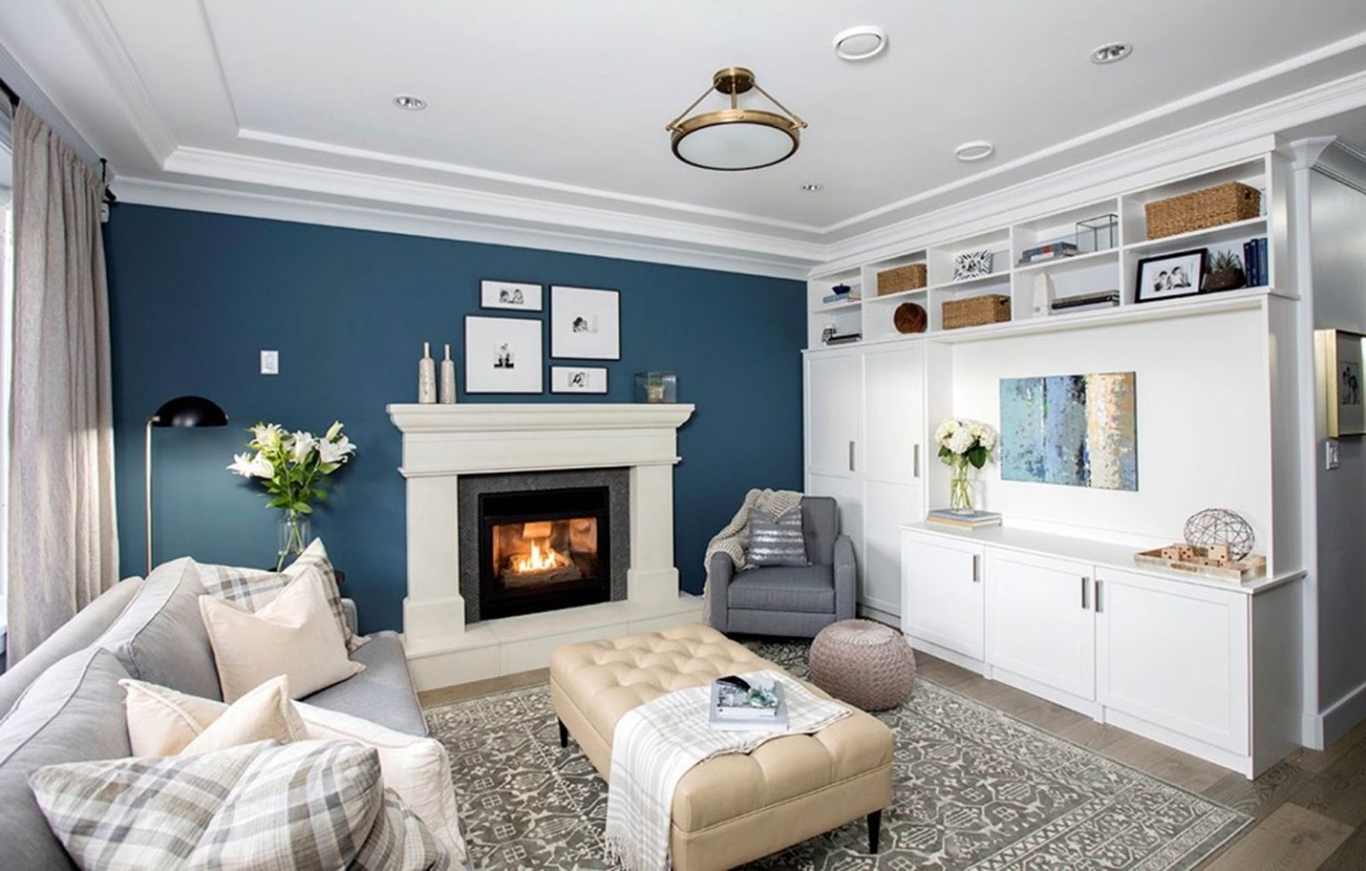 Living room with custom fireplace mantel, built-in shelving, and accent wall painted by Crown Max Decor
